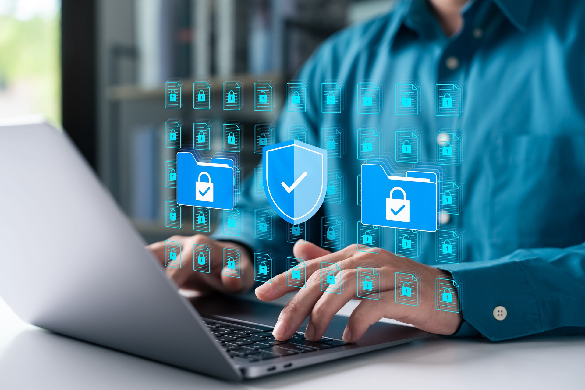 Cybersecurity concept with businessman using a laptop to protect data folders and digital files. Represents data privacy, secure information, and advanced cyber protection.